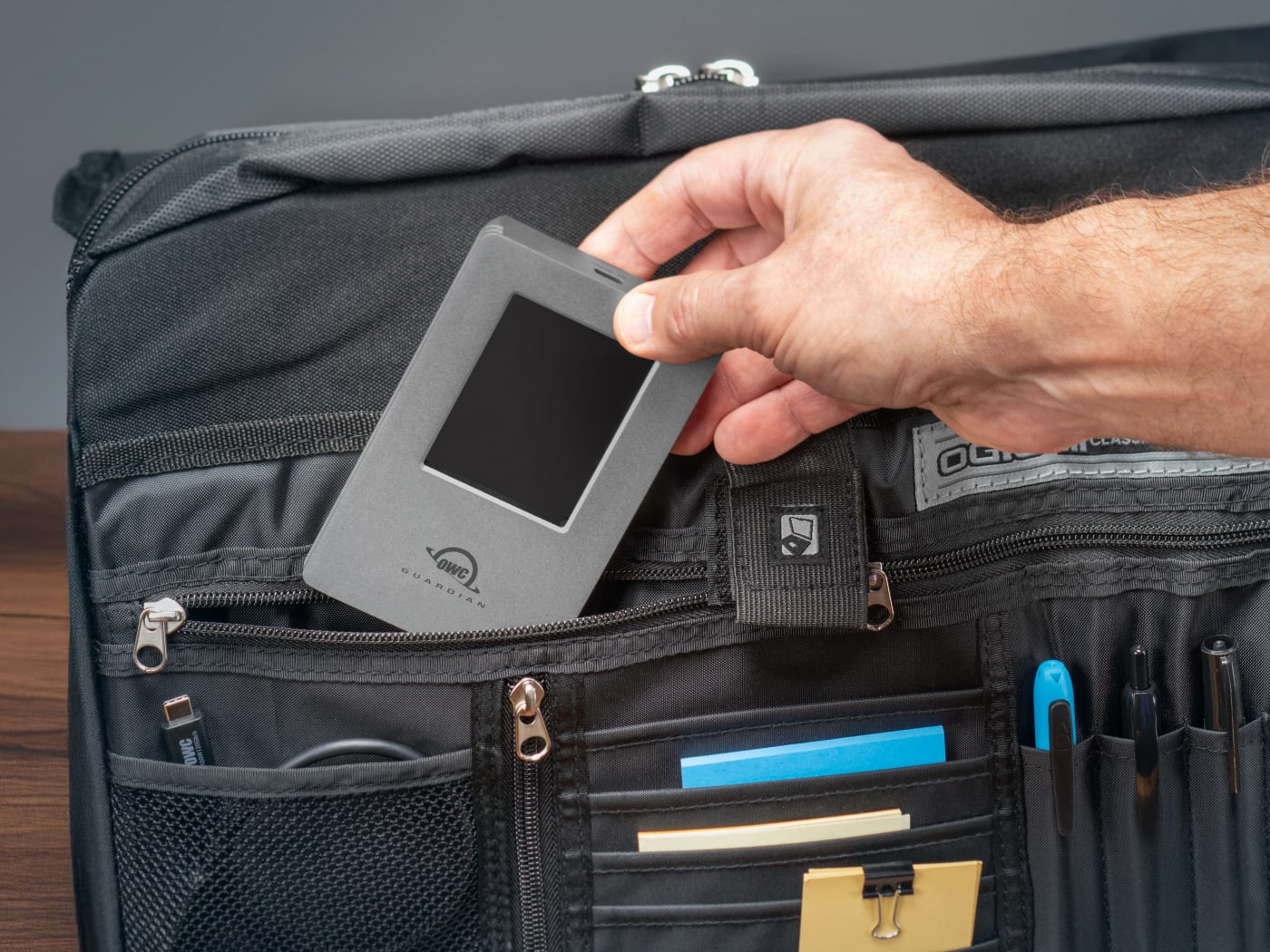 Closeu p of person putting OWC Guardian in a briefcase pocket