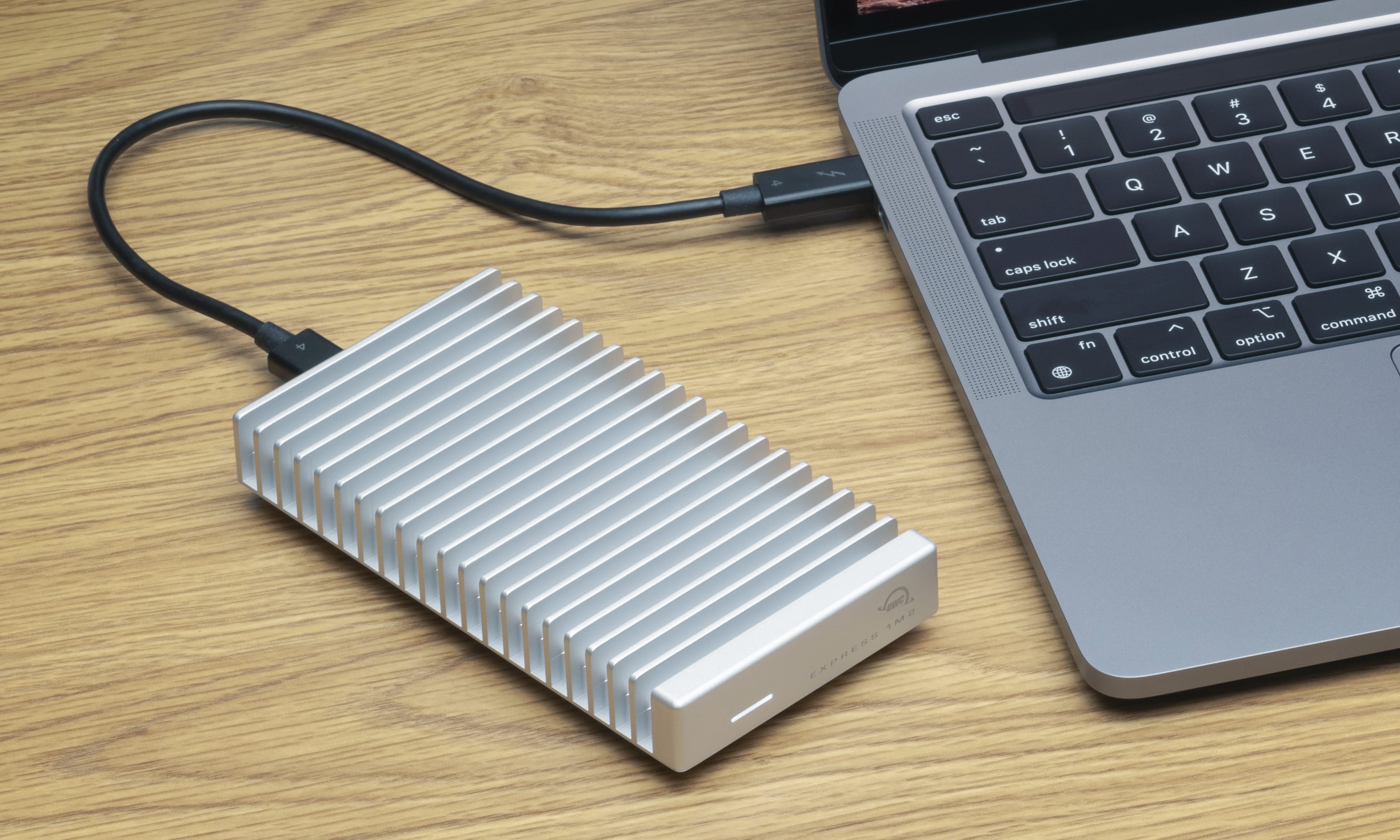 OWC Express 1M2 on desk with MacBook Pro