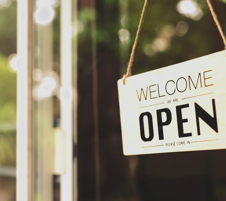 Window sign with text welcome we are open please come in