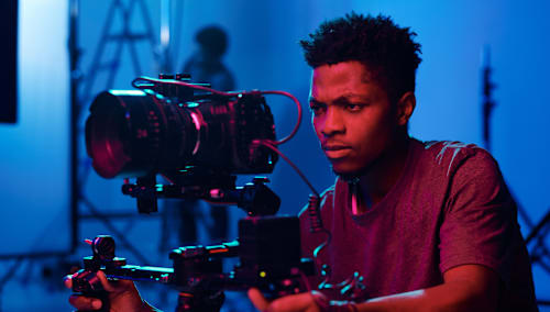 Man operating a camera with gimbal.