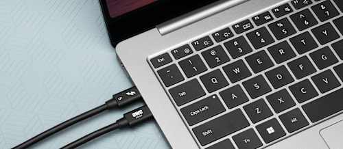 Closeup of two OWC Thunderbolt 5 Cables connected to a MacBook Pro