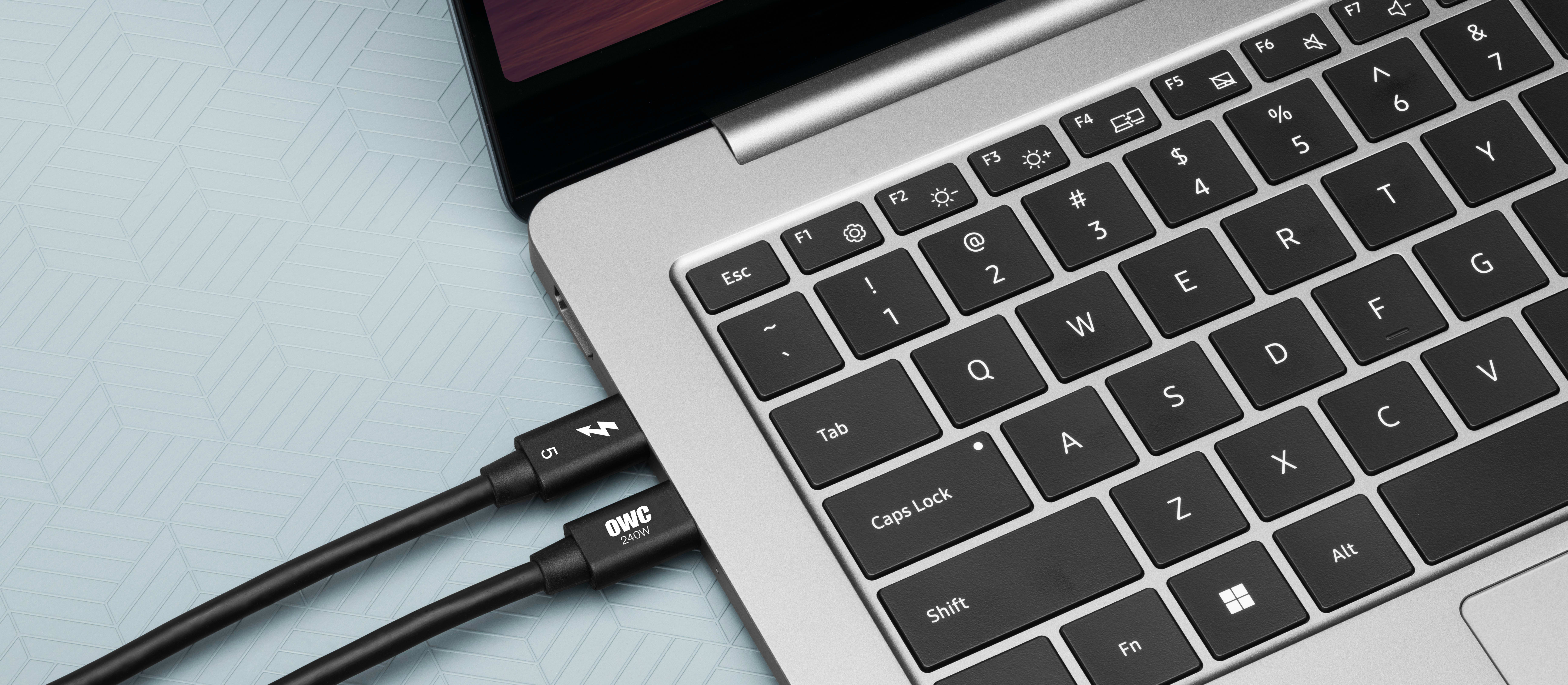 Closeup of two OWC Thunderbolt 5 Cables connected to a MacBook Pro