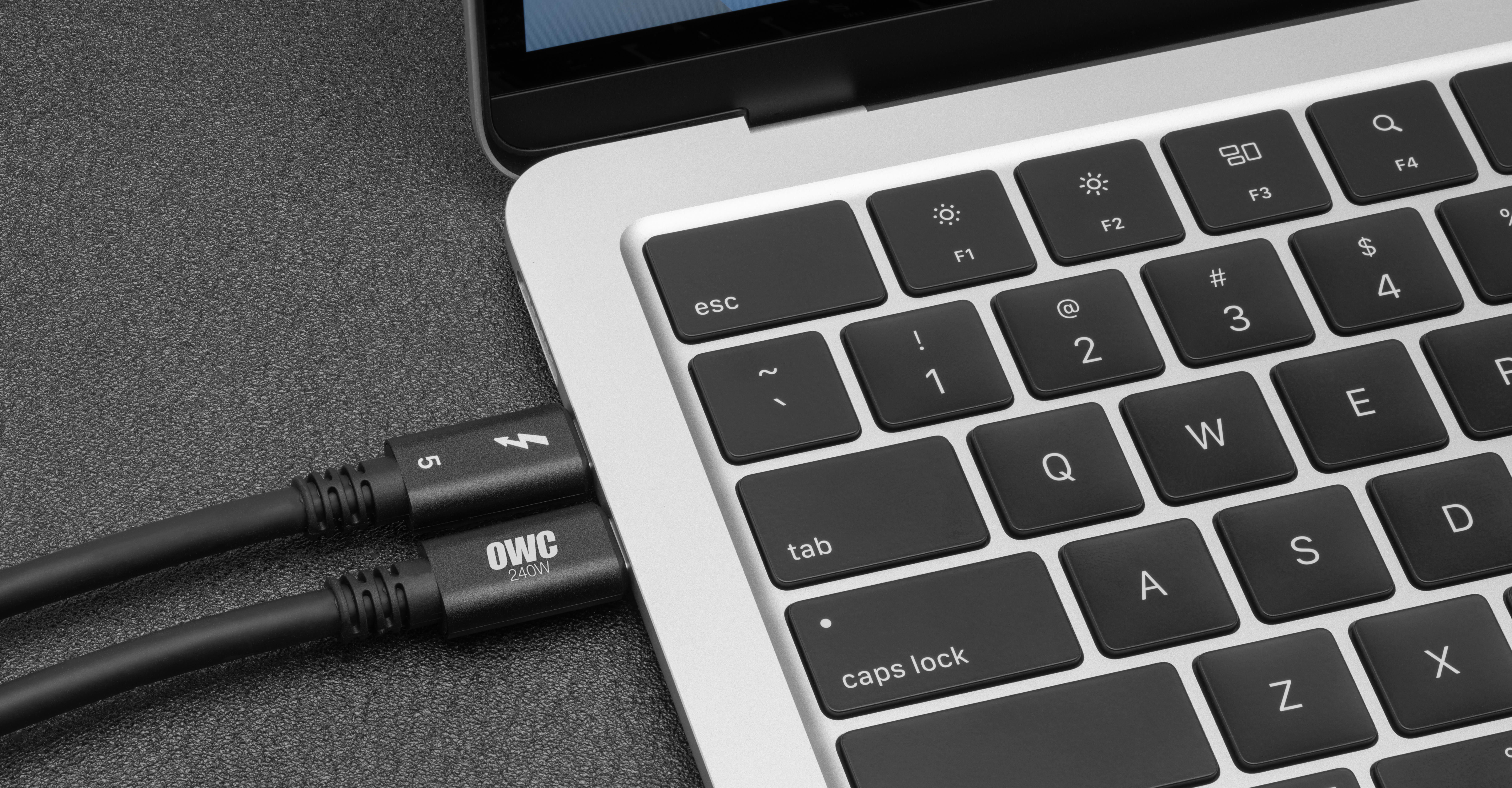 Closeup of two OWC Thunderbolt 5 Cables connected to a MacBook Pro