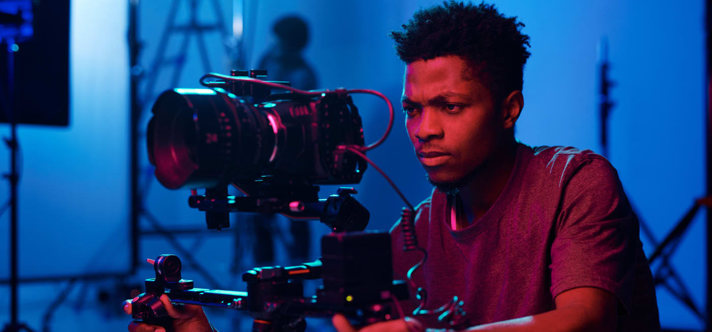 Professional videographer on set behind camera