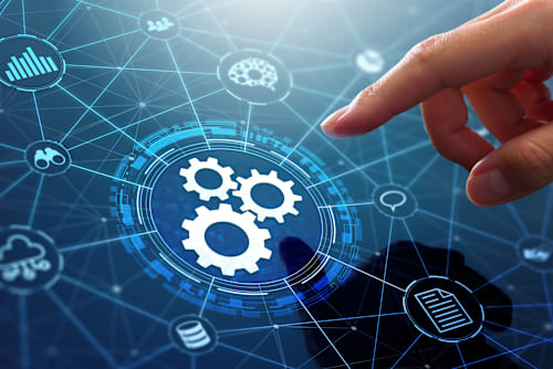 A hand reaching out to select a digital gear icon that is connected to a web of other icons that represent cloud services, documents, intelligence, and other data sources