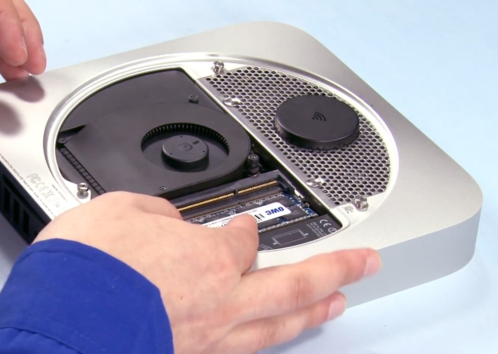 Hands installing OWC memory modules into a Mac mini (2011–2012)