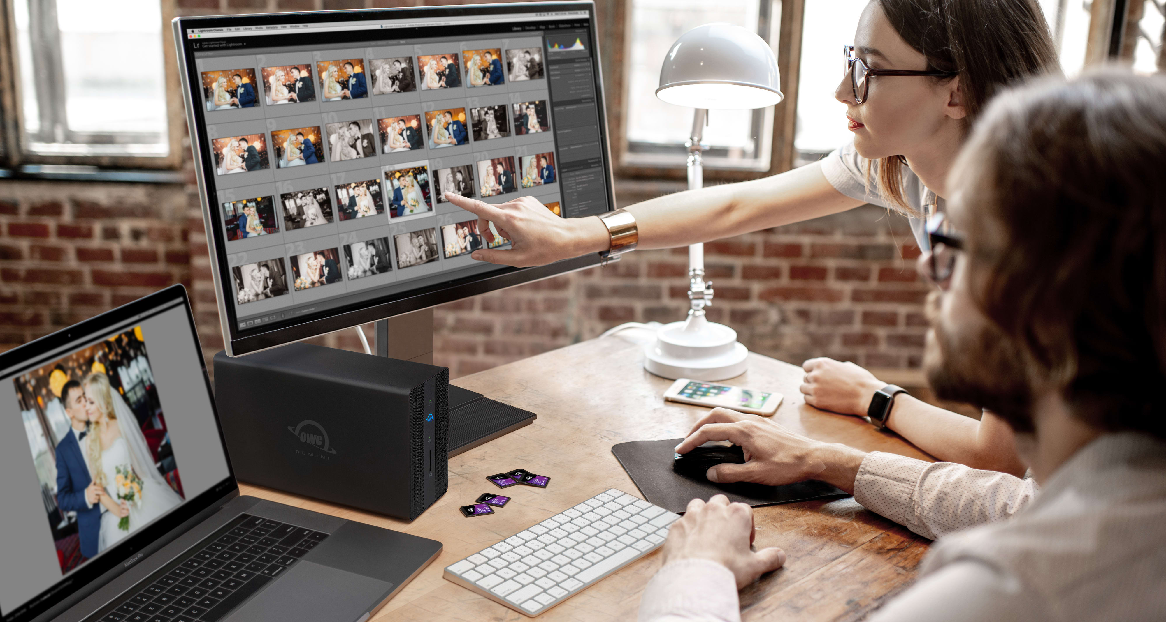 Two photographers reviewing images with OWC Gemini Ultra on desktop