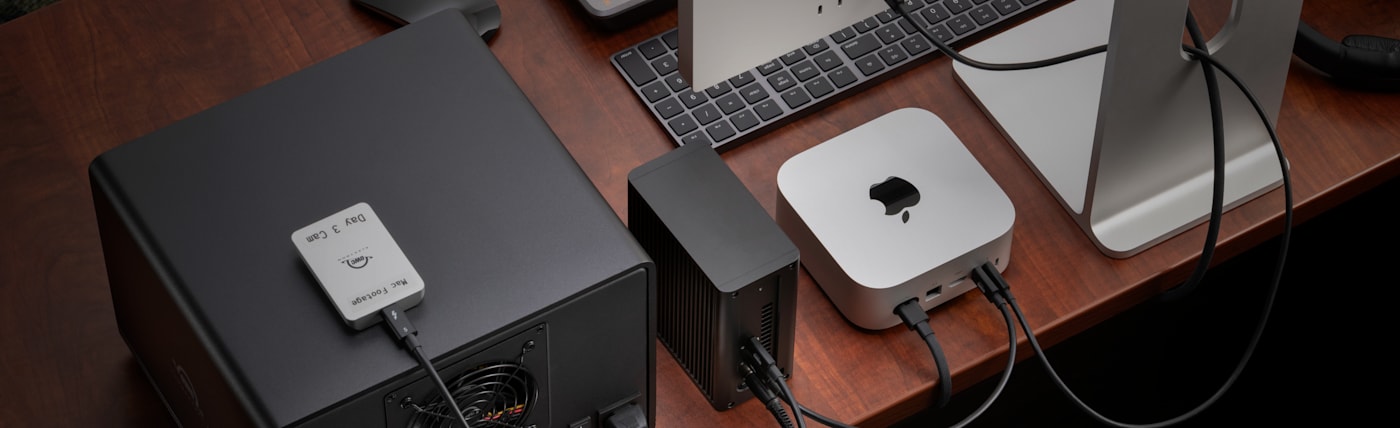 Rear, top-down view of OWC Express 4M2 Ultra on desktop connected to OWC Envoy, OWC ThunderBay 8, Mac mini, and display