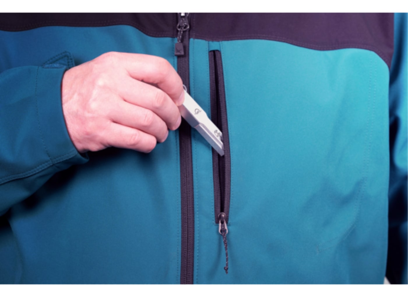 Envoy Pro mini being slipped into a jacket pocket