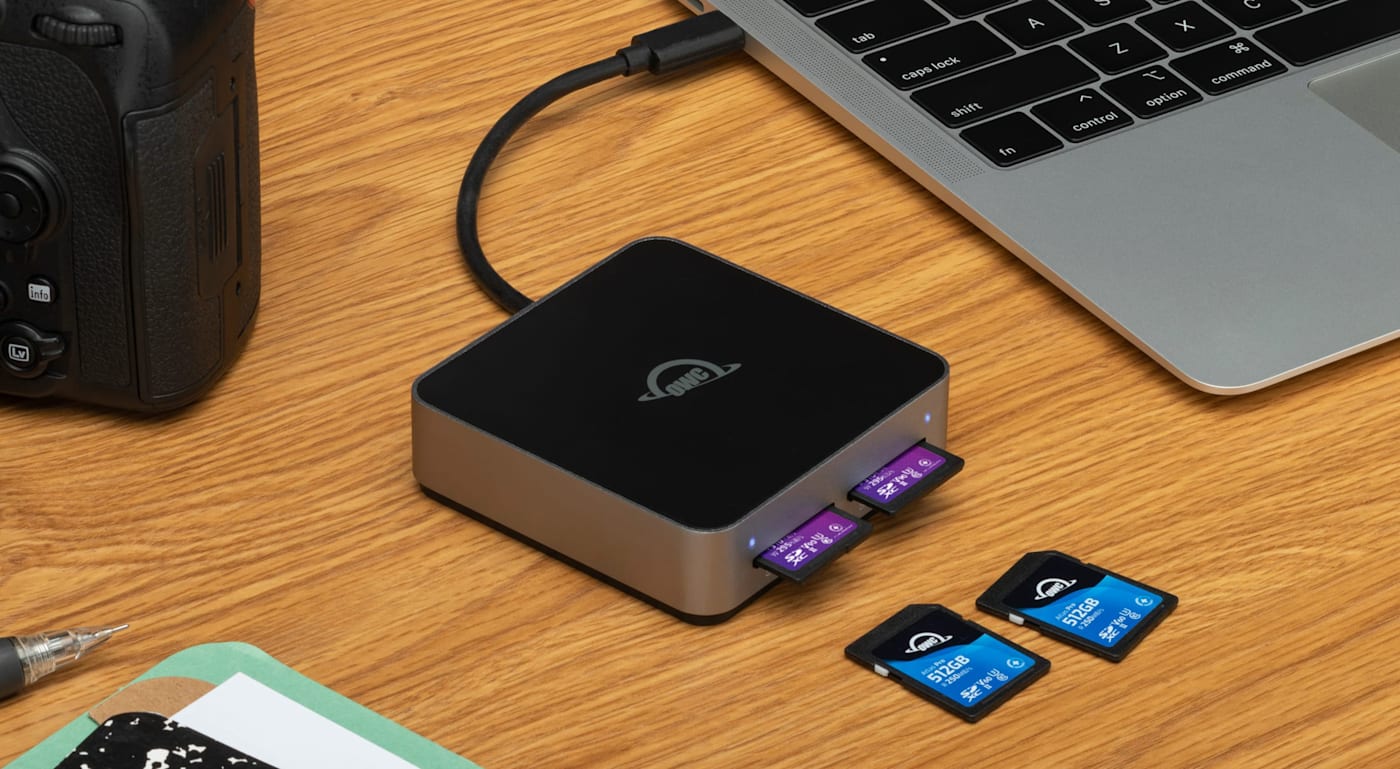 OWC Atlas Dual SD Card Reader on desktop with camera, media cards, and laptop