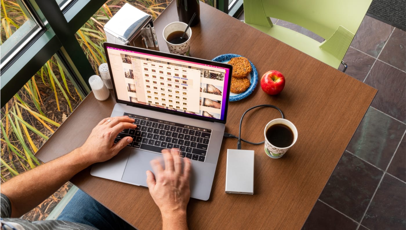 Mercury Elite Pro mini connected to a MacBook Pro on a tabletop in a cafe