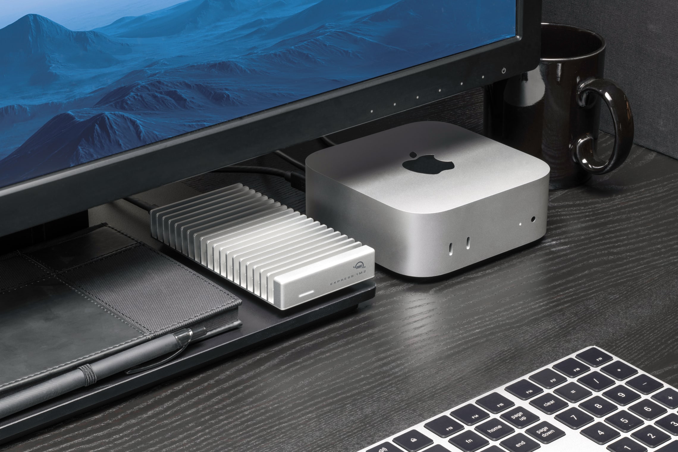 Closeup shot of an OWC Express 1M2 80G SSD on a desktop next to an Apple Mac Studio and a notebook