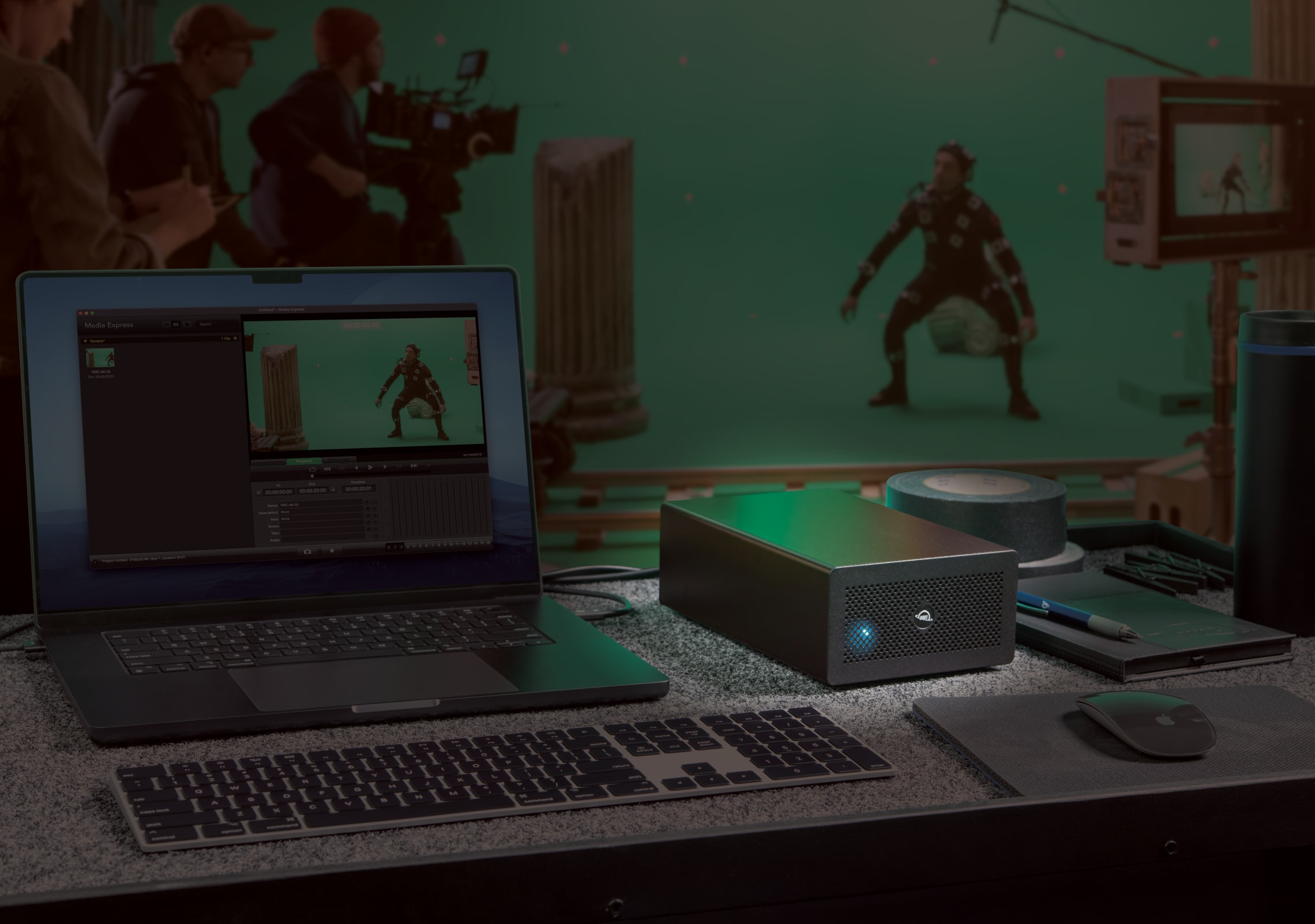 OWC Mercury Helios 5S Thunderbolt 5 PCIe Enclosure placed beside a MacBook Pro, showcasing its compact, space-saving design and professional integration.