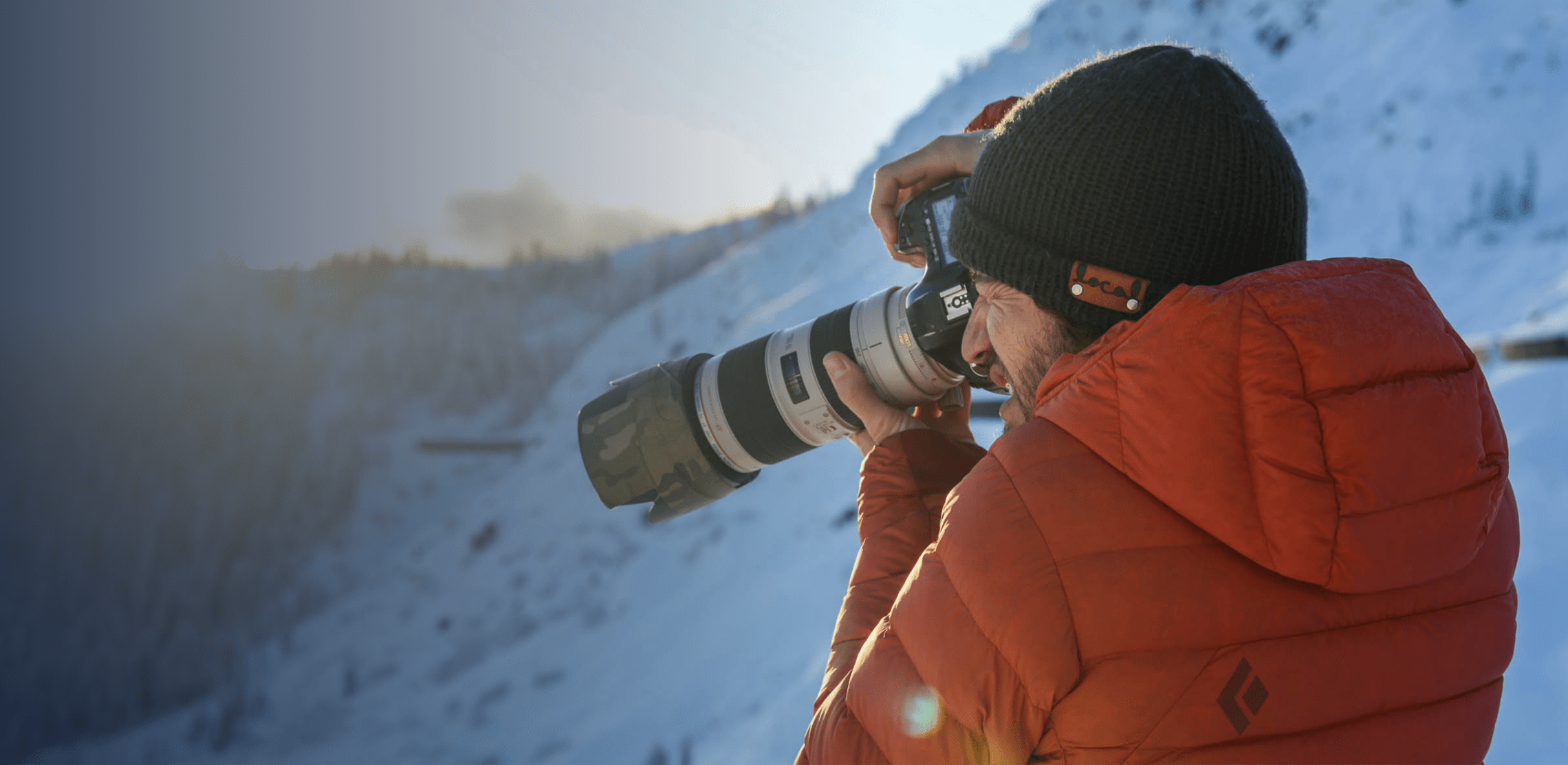 Closeup shot of a photographer holding a camera on a mountainside