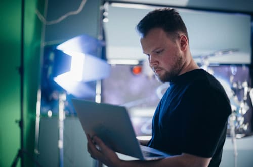A man using his laptop to remote in on another device