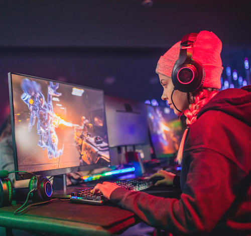 Woman with headset gaming on a computer.