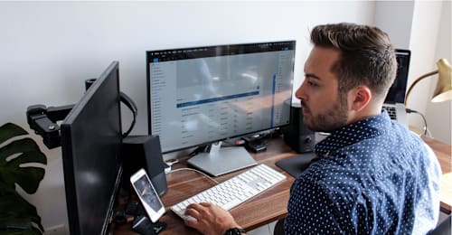 Man at desk using multiple monitors