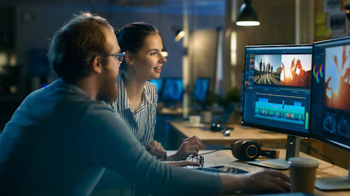 Two video editors at editing bay