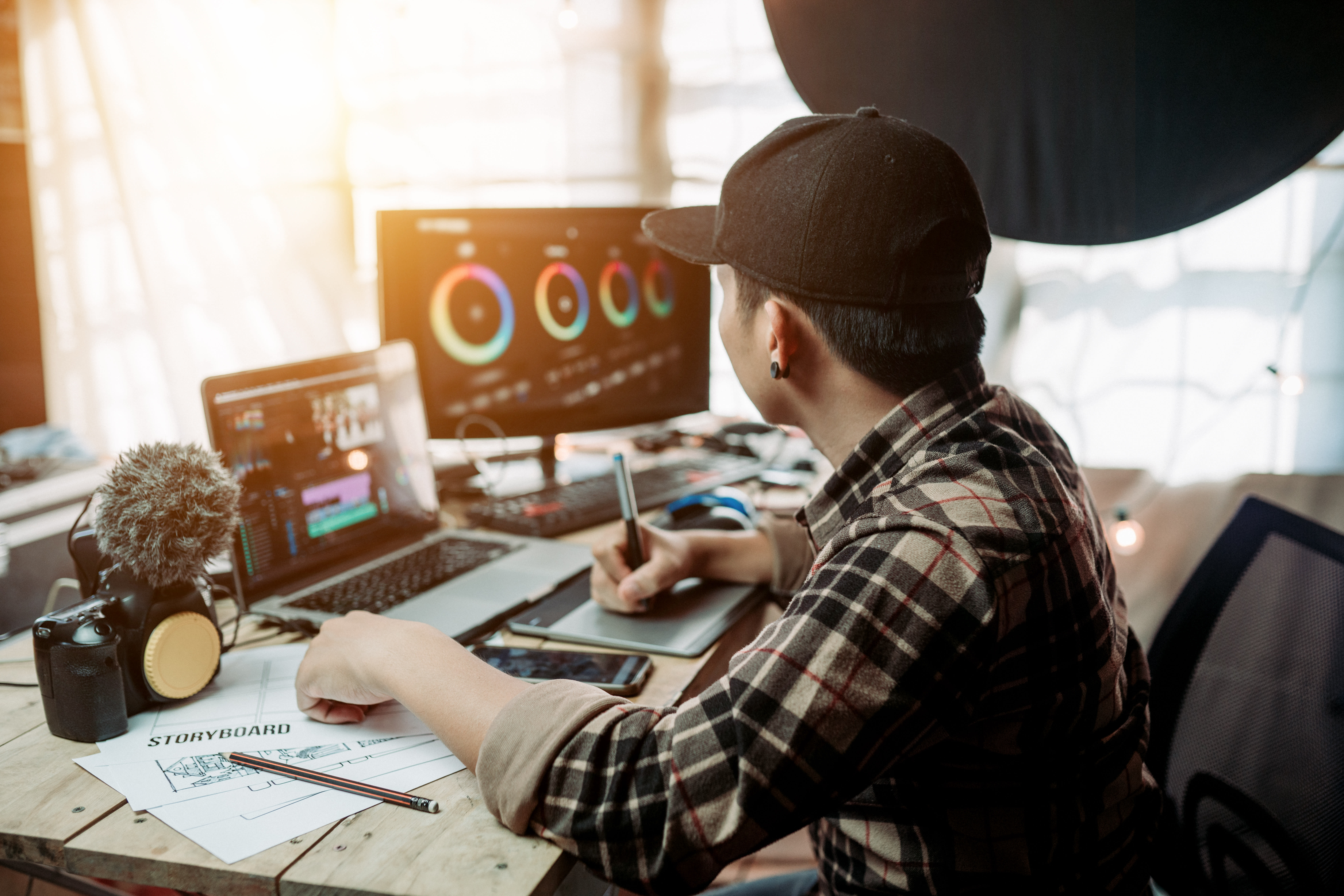 A individual is working on a story board and using editing software in the background