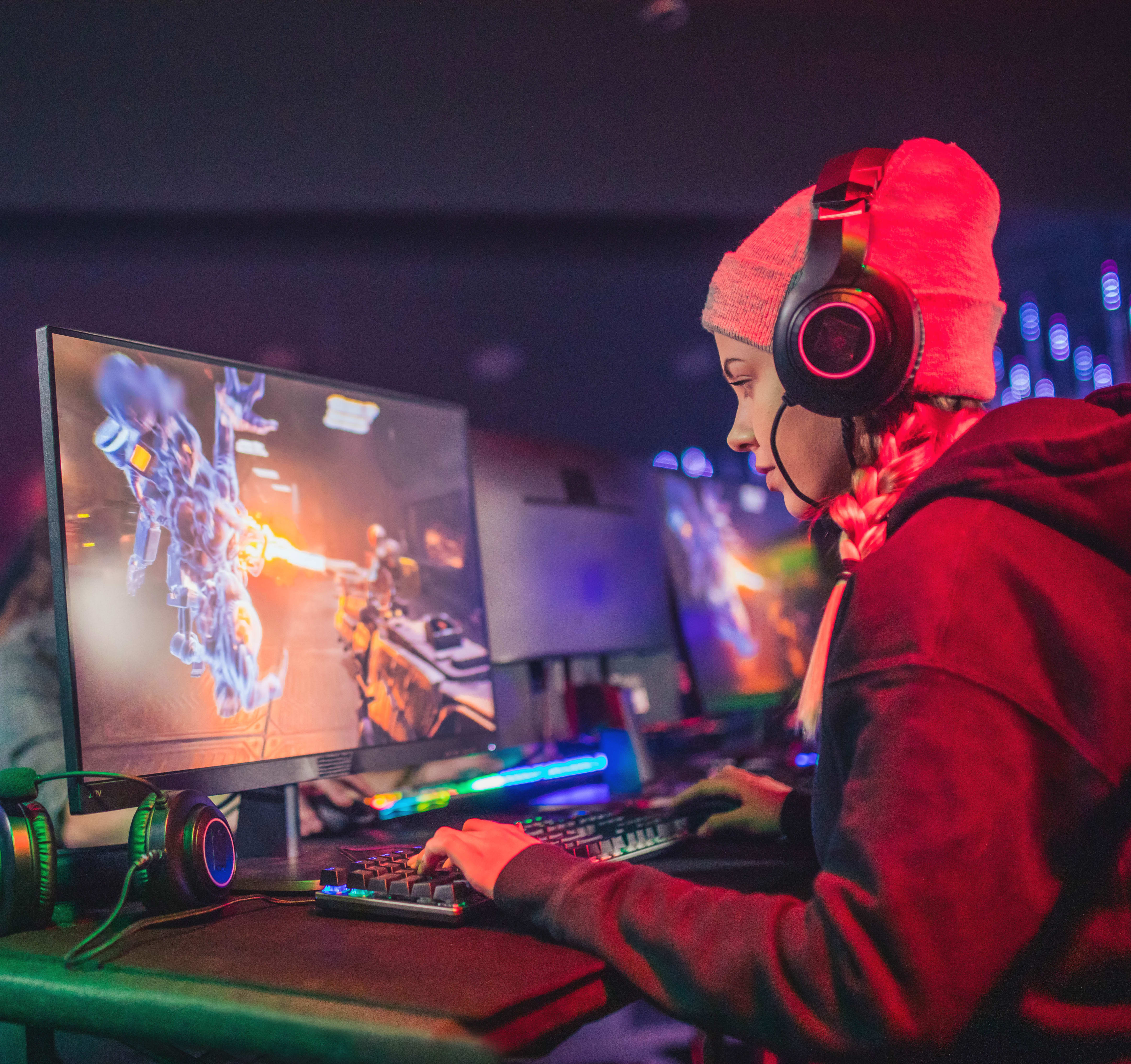 Woman with headset gaming on a computer.